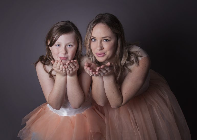 mom and daughter blowing a kiss