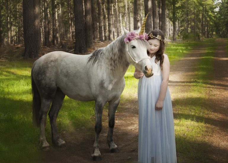 Girl and unicorn in an enchanted forest