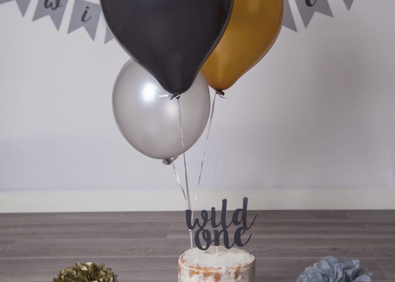 wild one themed cake smash with black and gold balloons