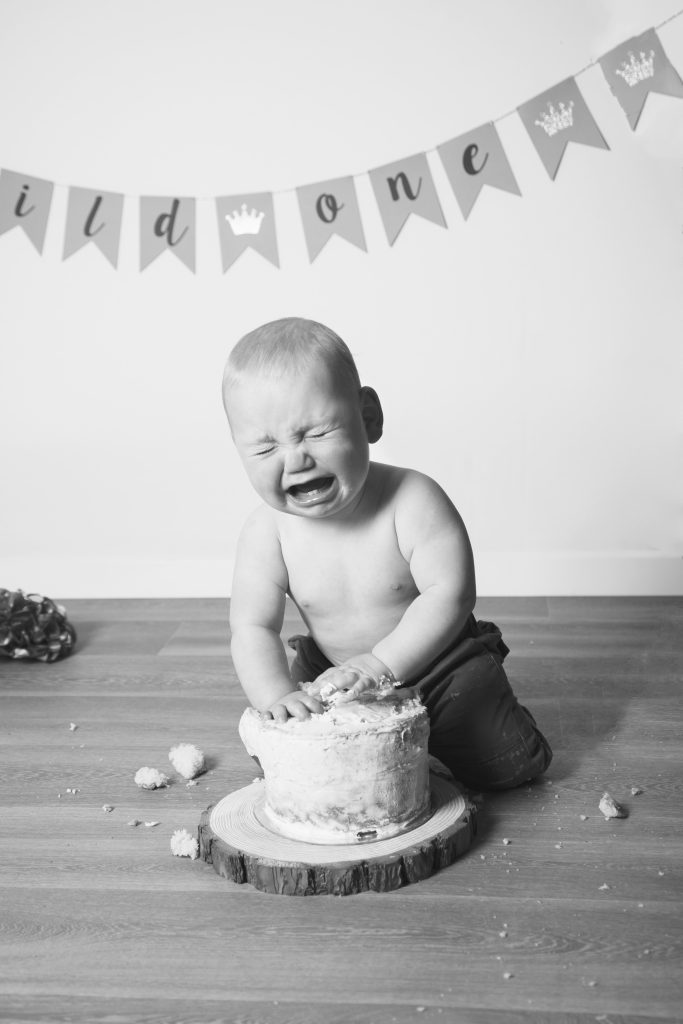boy crying while eating cake