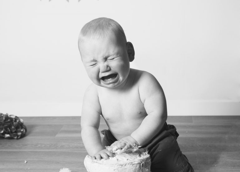 boy crying while eating cake