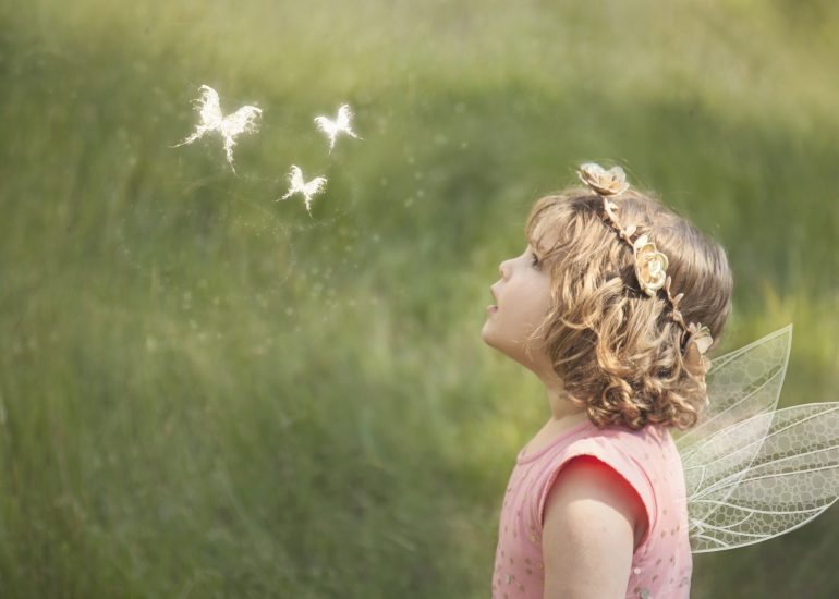 Girl looking up at magical butterflies