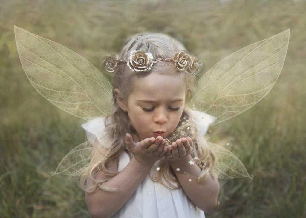 Fairy with wings blowing glitter kiss