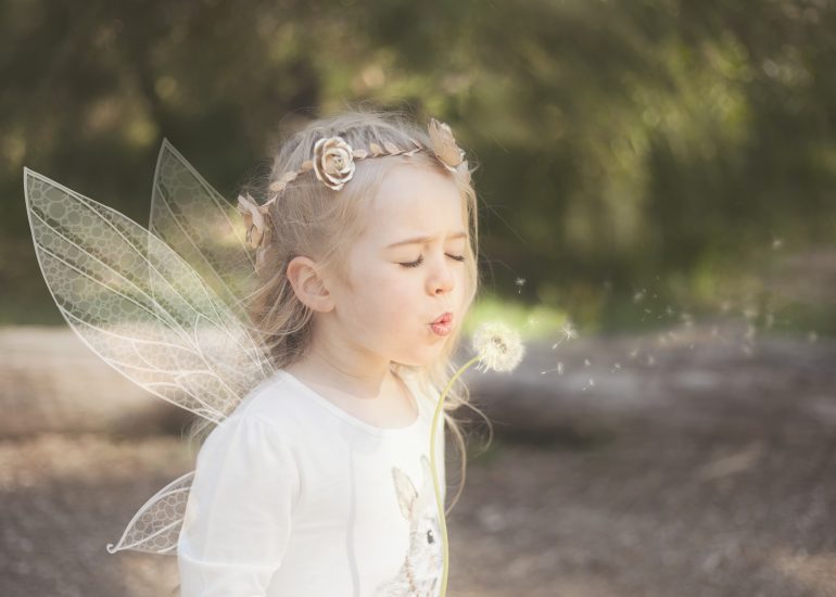 Girl Fairy blowing a dandelion and making a wish