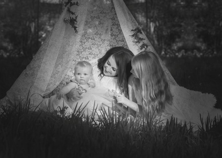 Mum and her daughters sitting in a lace teepee