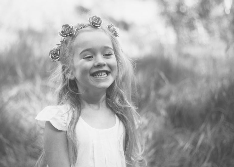Girl with flower crown smiling with teeth