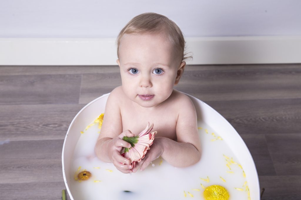 Boy in milk bath holding flower
